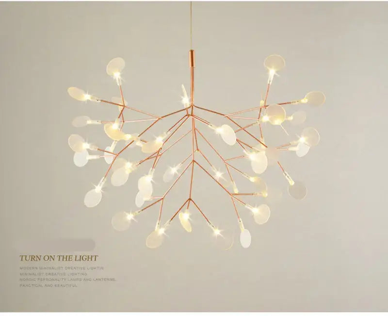 A modern DecorBites branch design nordic chandelier in rose gold and black with translucent discs and illuminated bulbs