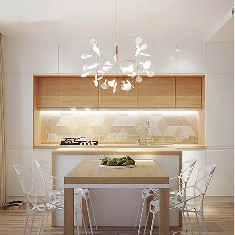 A modern rose gold black branch design nordic chandelier with spherical lights hangs above a kitchen island