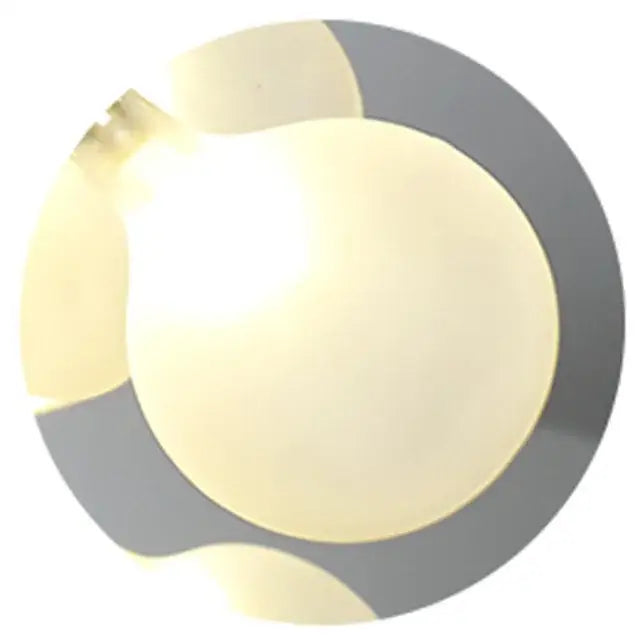 A glowing off-white led light bulb with metallic gray base and visible filament in decorbites branch iron black gold chandelier