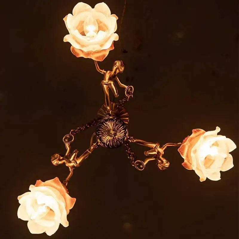 Decorbites brass angel chandelier with three illuminated rose-shaped lamps and sculpted cherub figures for living room
