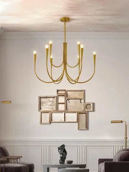 Gold-toned decorbites brass chandelier with multiple curved arms and lit bulbs for dining room lighting