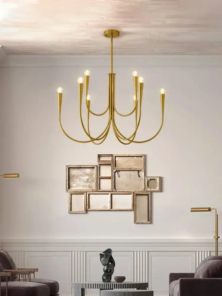 Gold-toned decorbites brass chandelier with multiple curved arms and lit bulbs for dining room lighting