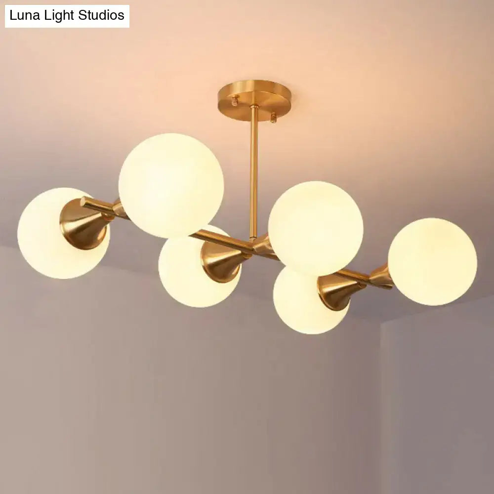 Gold-toned DecorBites brass finish linear island chandelier with six white clear frosted glass ball shades