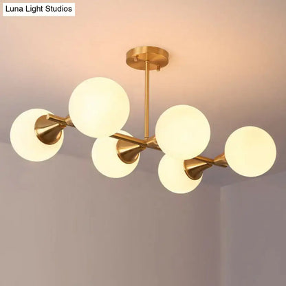 Gold-toned DecorBites brass finish linear island chandelier with six white clear frosted glass ball shades
