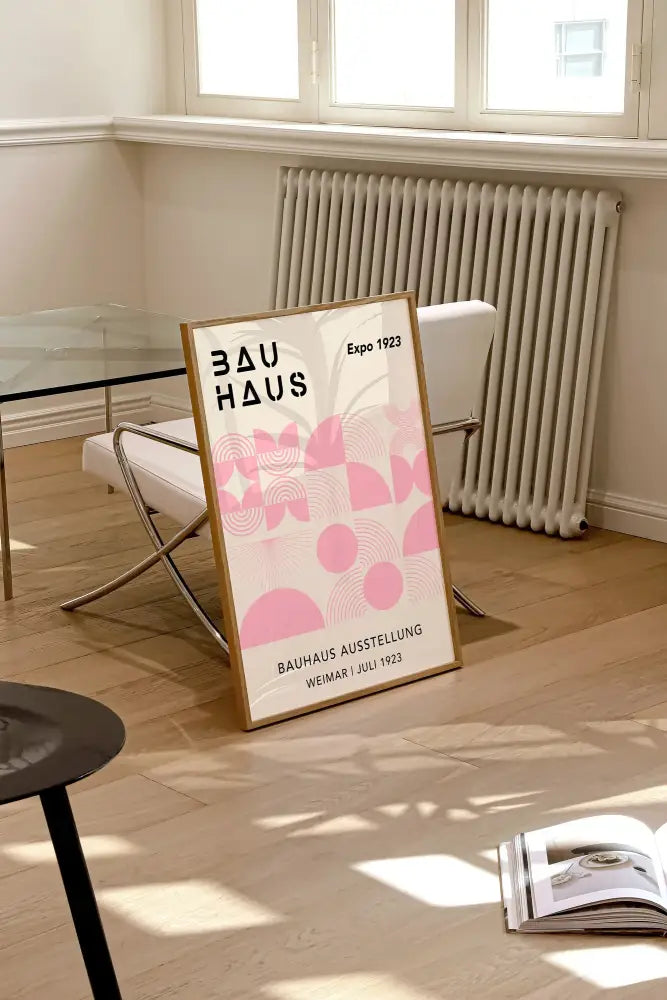 A framed decorbites bright geometric bauhaus canvas art print with pink patterns and black text in a light wood frame wall art