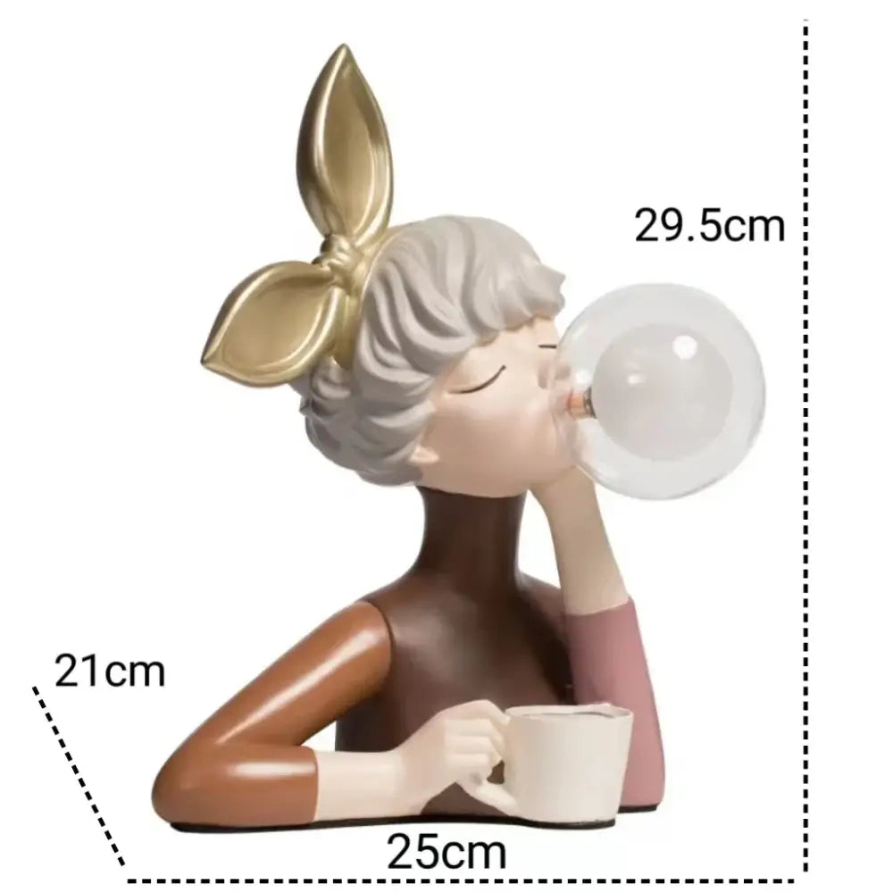 A charming decorbites bubble girl resin figurine with gray hair and gold bow blowing a bubble holding a white mug