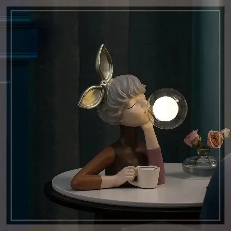 A decorbites bubble girl resin night light figurine with silver hair gold bunny ears holding a white cup and glowing orb