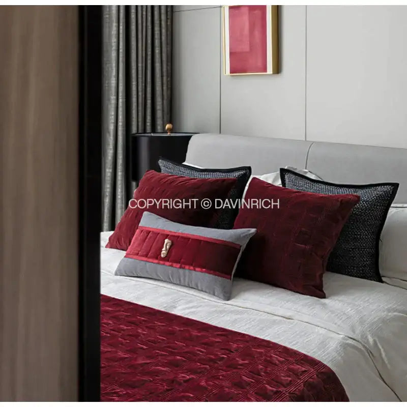 A plush decorbites burgundy velvet geometric embroidered bed runner with quilted diamond pattern on bed
