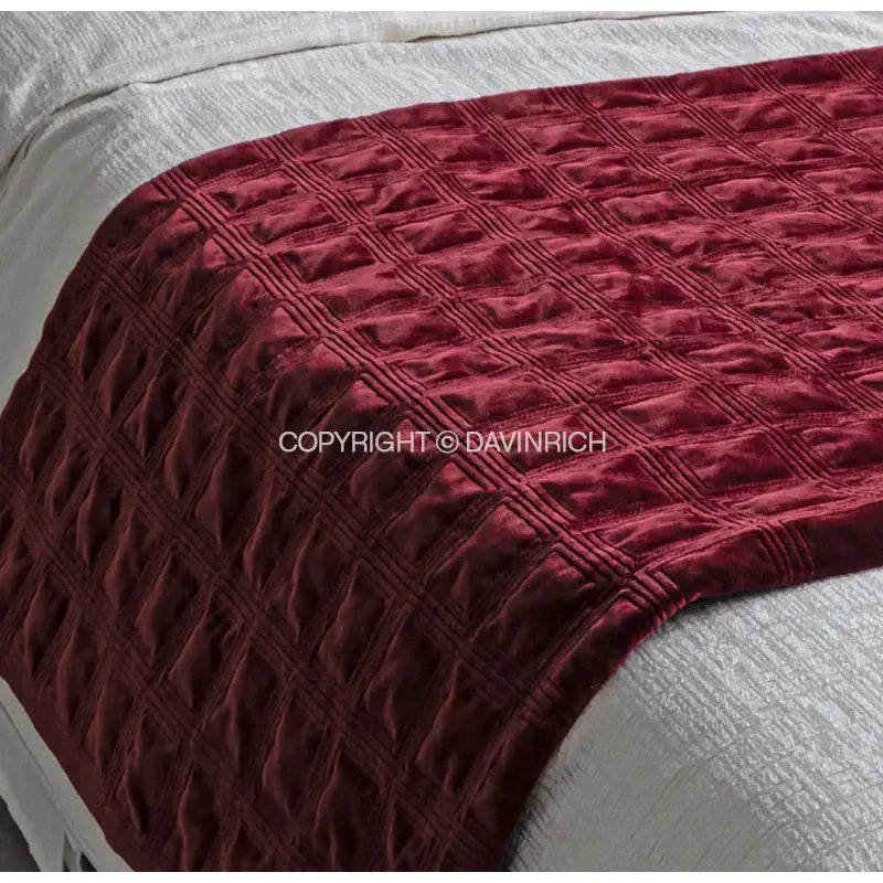 A decorbites burgundy velvet bed runner with a quilted diamond geometric embroidered pattern for bedroom decor