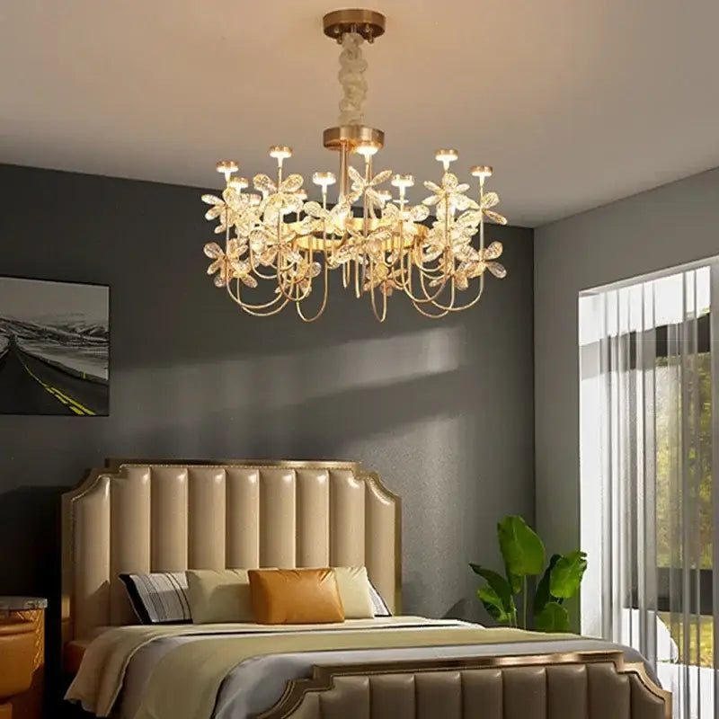 Gold-toned decorbites butterfly chandelier with crystal flower accents hanging above a bed in a dining room setting