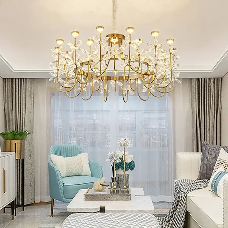 Gold-toned decorbites butterfly chandelier with crystal flower accents hanging from the ceiling for dining room lighting