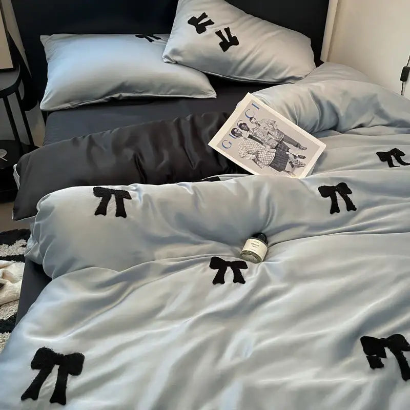Light blue satin duvet cover with black embroidered bow patterns featuring decorbites butterfly embroidered design