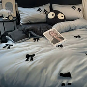 Black plush pillow with large white eyes and stitched black pi symbols featuring decorbites butterfly embroidered design