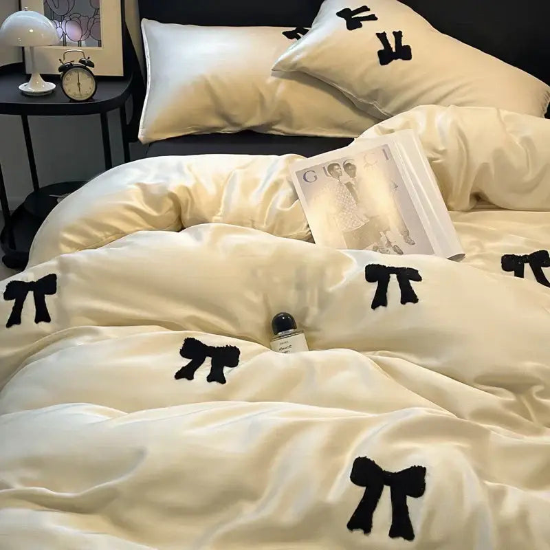 Cream-colored satin duvet cover with black embroidered bows featuring decorbites butterfly embroidered design