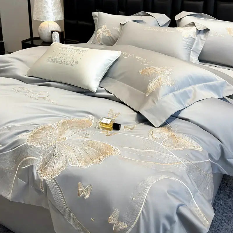 Light blue satin bedding set with intricate gold decorbites butterfly embroidery and delicate lace detailing for luxury bedroom
