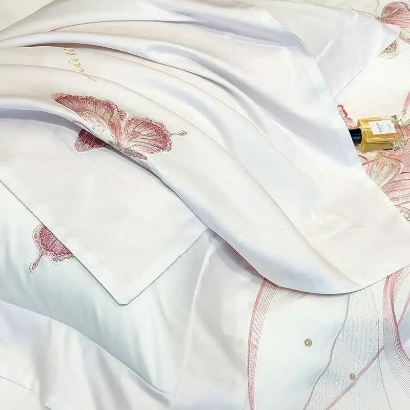 White satin pillowcase with delicate pink decorbites butterfly embroidery and subtle lace trim from luxury bedding set