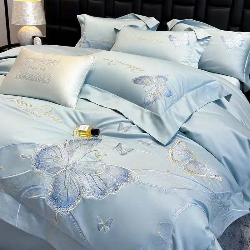 Light blue satin bedding set with decorbites butterfly embroidery in blue silver and gold thread accents luxury design