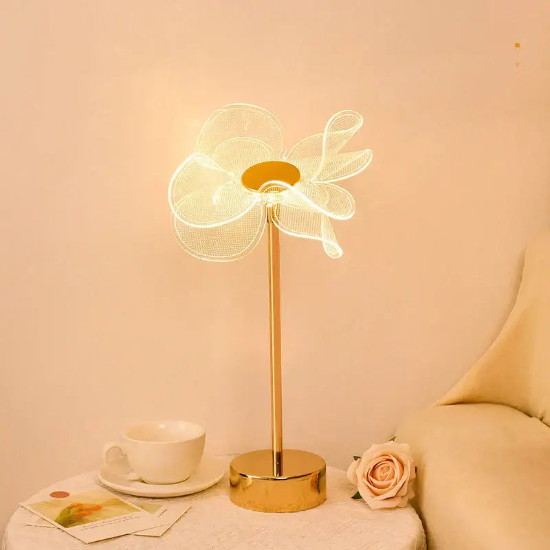 Gold-toned desk lamp with delicate glowing wireframe flower design in decorbites butterfly gold acrylic style for living room