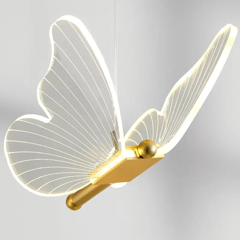 A modern gold-toned decorbites butterfly pendant light with translucent led-illuminated wings for dining rooms