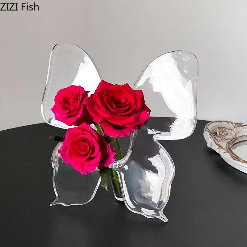Clear acrylic butterfly vase holding three vibrant red roses for aesthetic room decor by DecorBites™