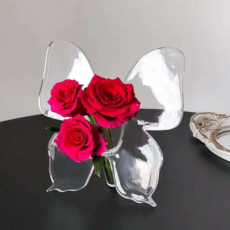 Clear glass butterfly vase holding three vibrant red roses for aesthetic room decor and butterfly vase display