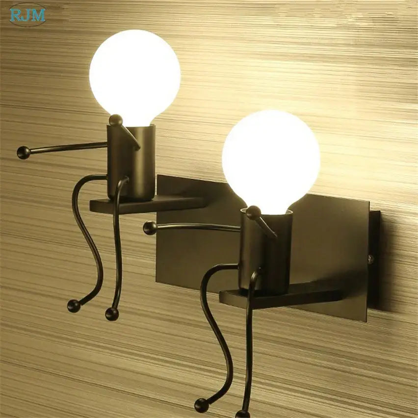Black metal wall lamps shaped like cartoon children with spherical bulb heads decorbites cartoon children iron design