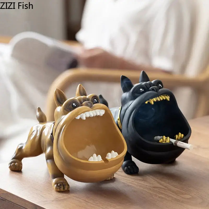 Two stylized decorbites cartoon dog ashtrays in tan and black resin with gold accents for living room decor