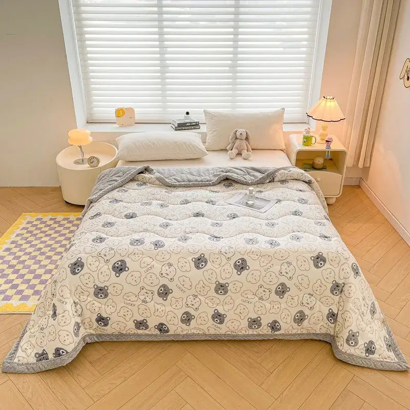 Cream velvet quilted blanket with decorbites cartoon print featuring gray and black bears and soft textured surface