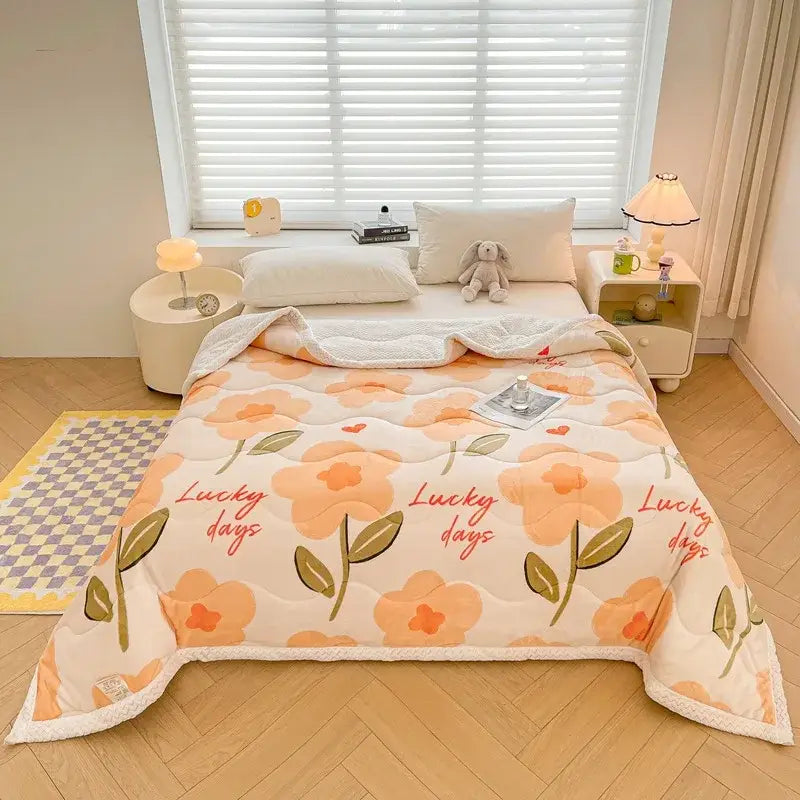 A cozy peach and cream floral decorbites cartoon print velvet quilted blanket with soft plush edges for bedroom use