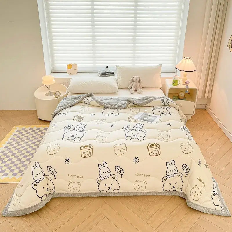 Cream-colored decorbites cartoon print velvet quilted blanket with playful bears and bunnies, soft gray trim