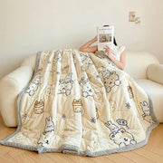 Cream velvet quilted blanket with plush texture and decorbites cartoon print featuring bunnies and gift boxes in navy and gold
