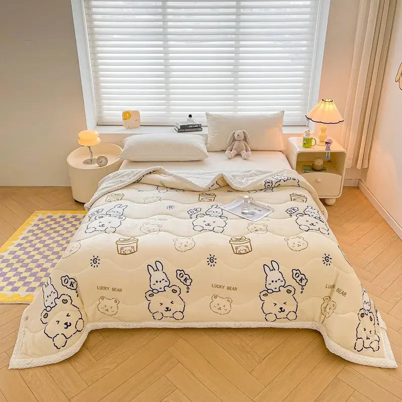 Cream-colored velvet quilted blanket with decorbites cartoon print featuring bears and bunnies holding gifts