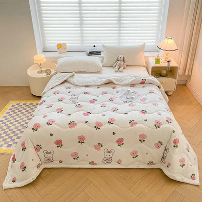 A cream velvet quilted blanket with decorbites cartoon print featuring pink roses and playful bunnies for bedroom bedding