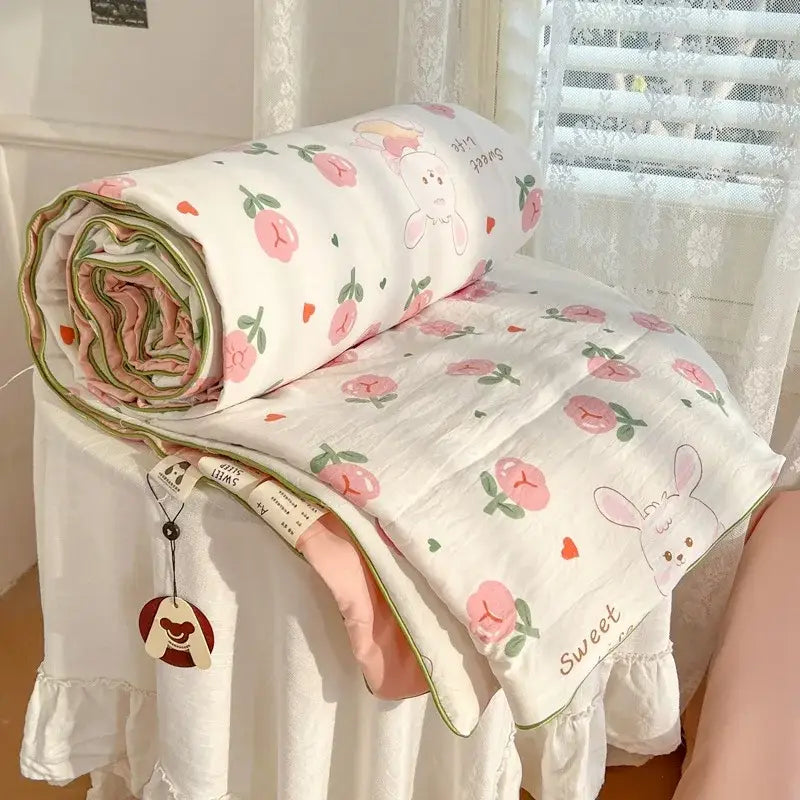 A soft white cotton decorbites cartoon summer cream teddy bear blanket with pink peach bunny print and green piping edges