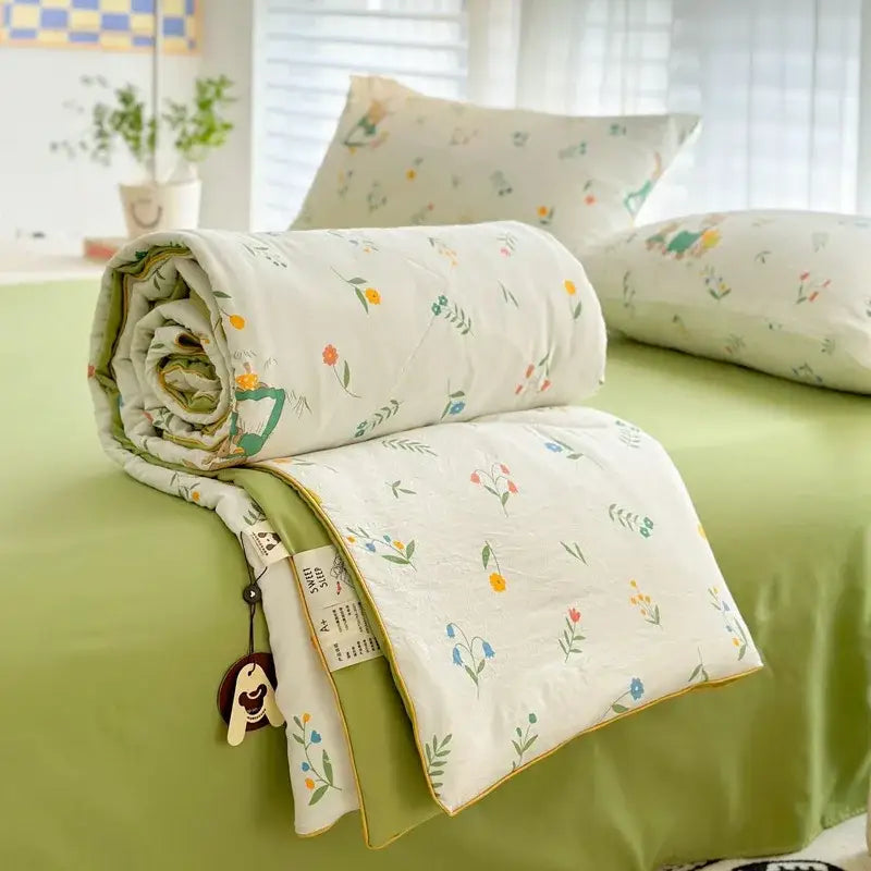 A soft rolled-up decorbites cartoon summer cotton blanket with pastel floral pattern for bedroom bedding use