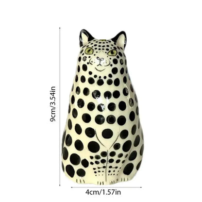 Cream-colored ceramic dot cat figurine with black spots and green eyes in decorbites polka dot cat vase
