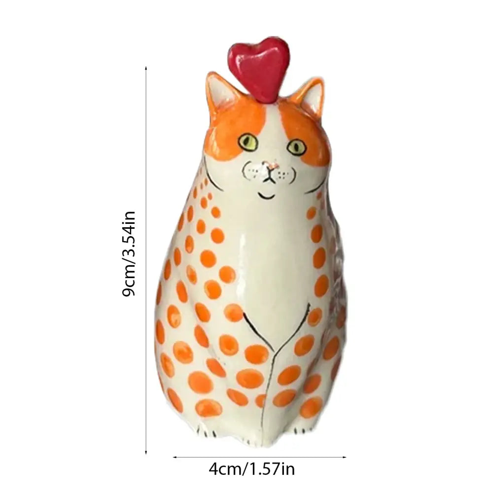 A charming orange and white polka dot cat vase made of resin with a glossy finish and a red heart topper