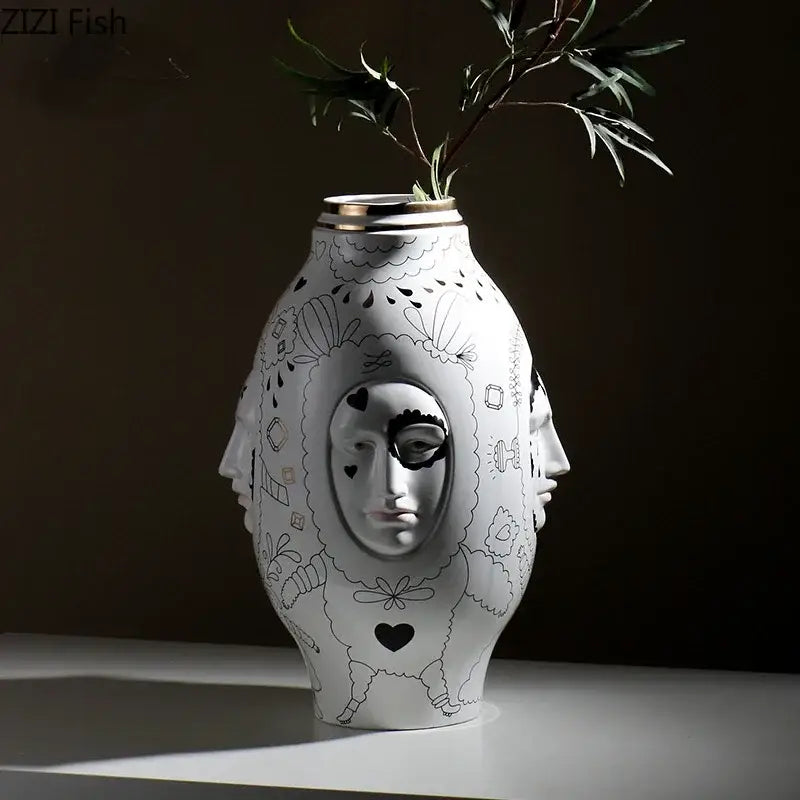 White ceramic vase desktop with black hand-drawn face pattern and gold rim for floral arrangements by DecorBites™