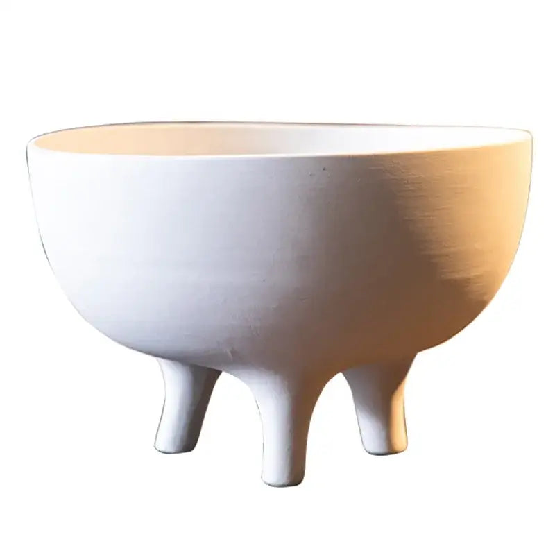 White ceramic flower pot with tripod stand featuring a smooth matte finish and slightly curved sides by DecorBites