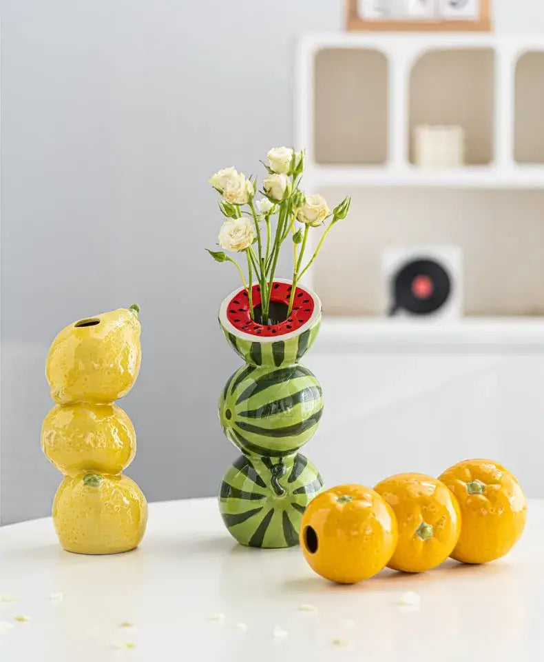 Decorbites™ ceramic fruit vase shaped like a green and black striped watermelon with red interior holding white flowers