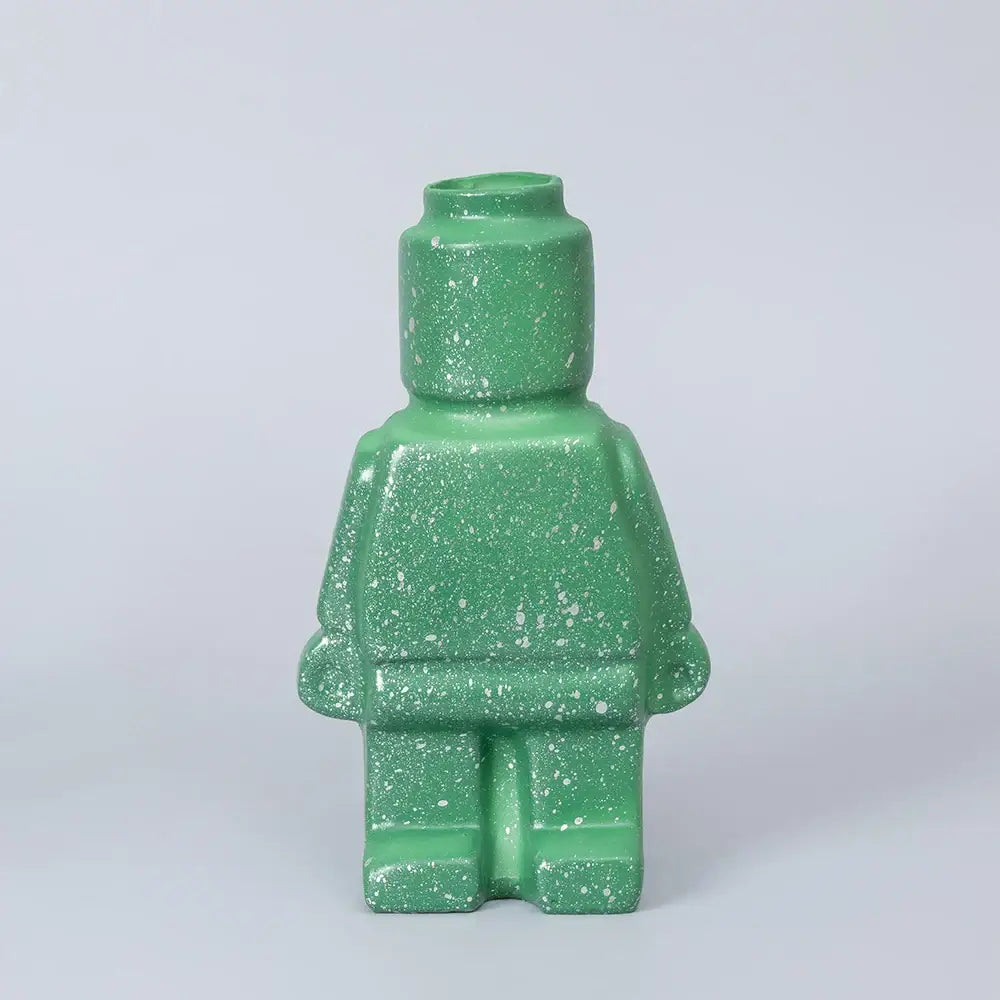 A green speckled ceramic robot vase shaped like a lego minifigure perfect for nordic style home decor
