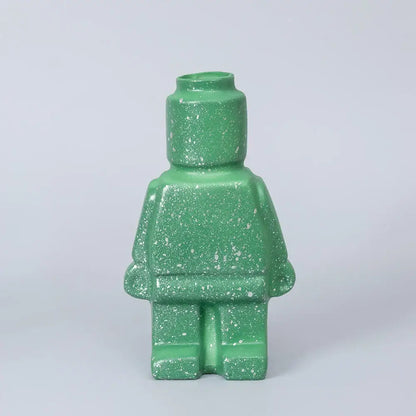 A green speckled ceramic robot vase shaped like a lego minifigure perfect for nordic style home decor