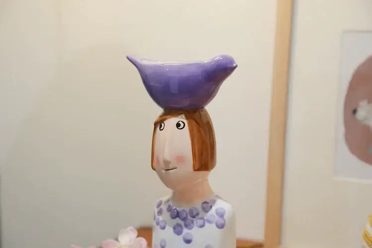 Decorbites™ ceramic vase set featuring a figurine with painted face, brown bobbed hair, and purple polka dot dress for home decor