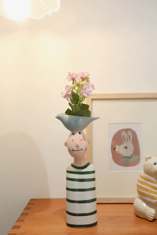 DecorBites ceramic vase set featuring a green and white striped smiling figure with a blue bird opening and pink flowers for home decor