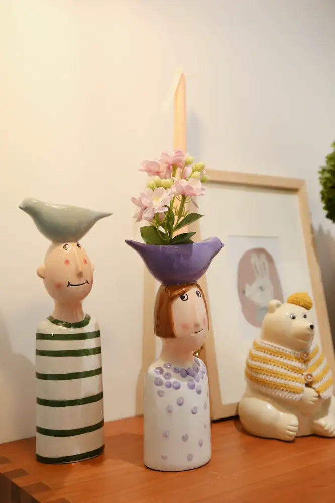 DecorBites™ ceramic vase set featuring a white ceramic vase shaped like a woman with brown hair and a purple hat for home decor