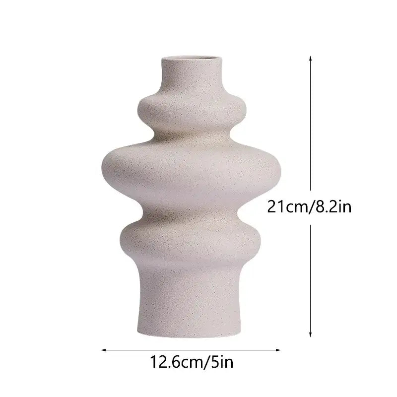 A sleek off-white ceramic vase with textured speckled finish and abstract tiered design ideal for modern home decor