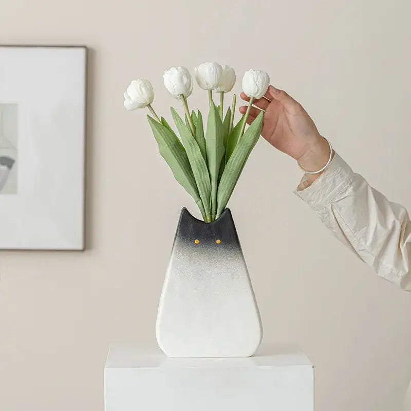 Decorbites charming cat-inspired ceramic vase with gradient black-to-white finish and gold dot eyes holding white tulips