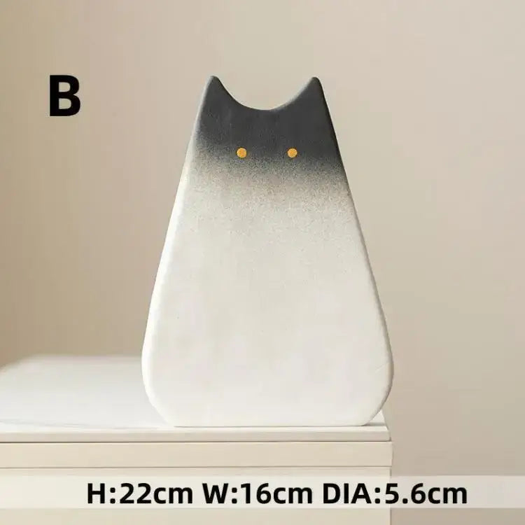 A sleek black-and-white ceramic vase shaped like a cat with golden eyes ideal as a living room cat ceramic vase