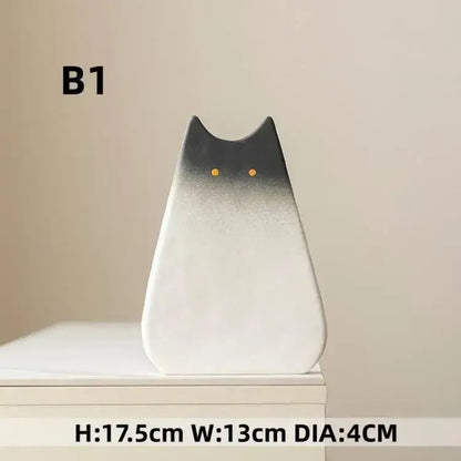 A sleek minimalist cat ceramic vase by decorbites with a black to white gradient and golden eyes for living room decor