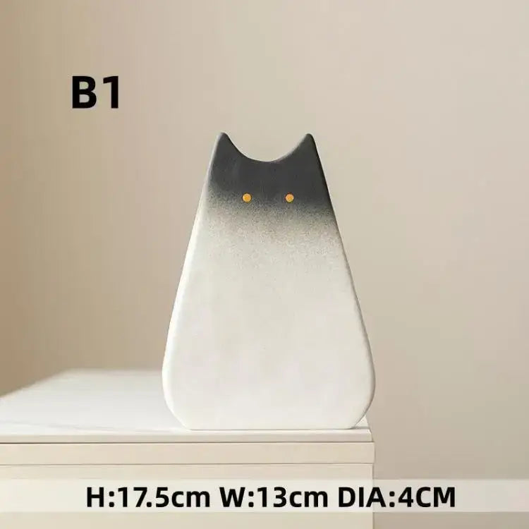 A sleek minimalist cat ceramic vase by decorbites with a black to white gradient and golden eyes for living room decor